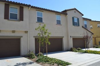 a house with three garage doors and a sidewalk at The Vines at Riverpark, LLC, California, 93036